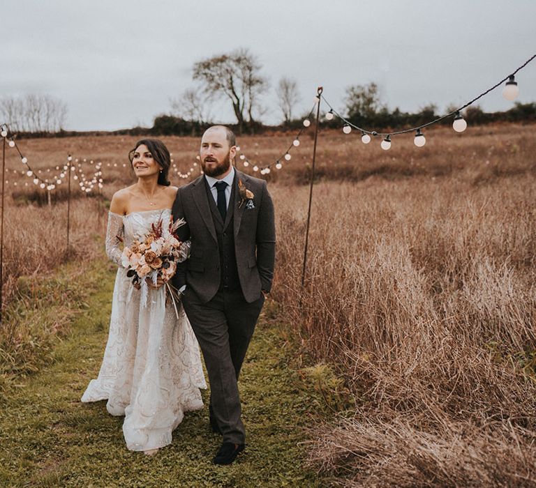 Groom in dark grey suit and bride in sparkly sequinned Zavana Couture wedding dress in Devon