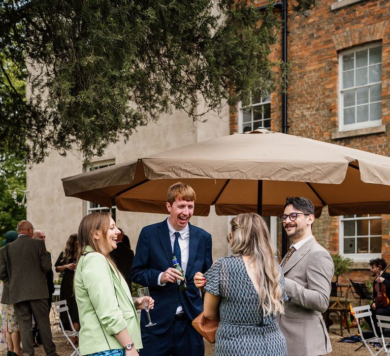 Wedding guests socialise around at the wedding 