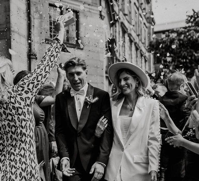 Bride and groom walk through heart shaped confetti after their town hall wedding 