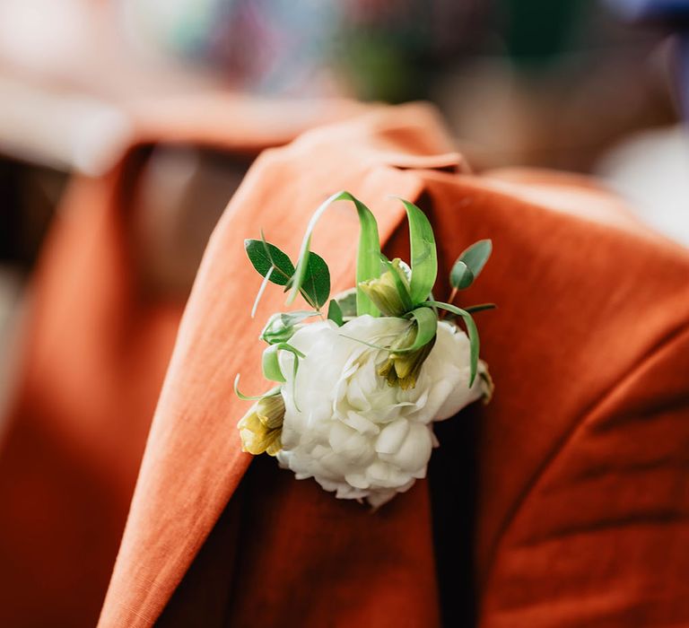 Groom wears orange Paul Smith suit complete with white floral buttonhole 