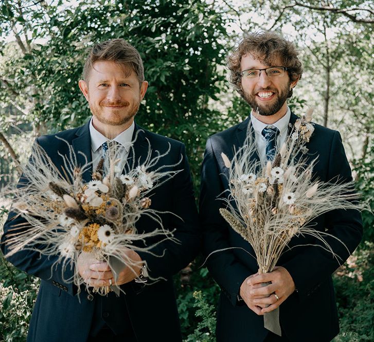 Groomsmen hold dried floral bouquets