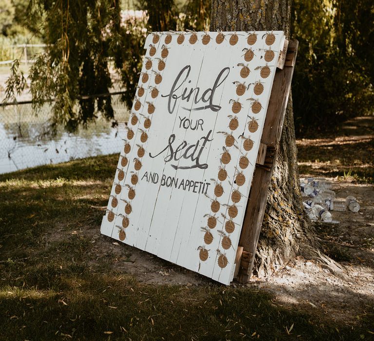 DIY pallet seating chart painted white and name tags tied with brown string