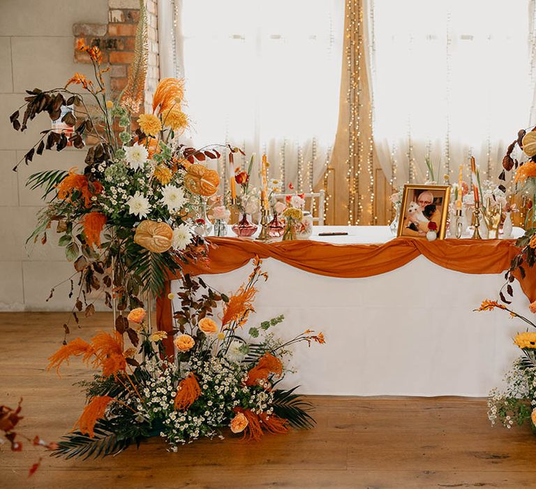 Wedding table decorations with orange and yellow wedding flowers and fairy lights