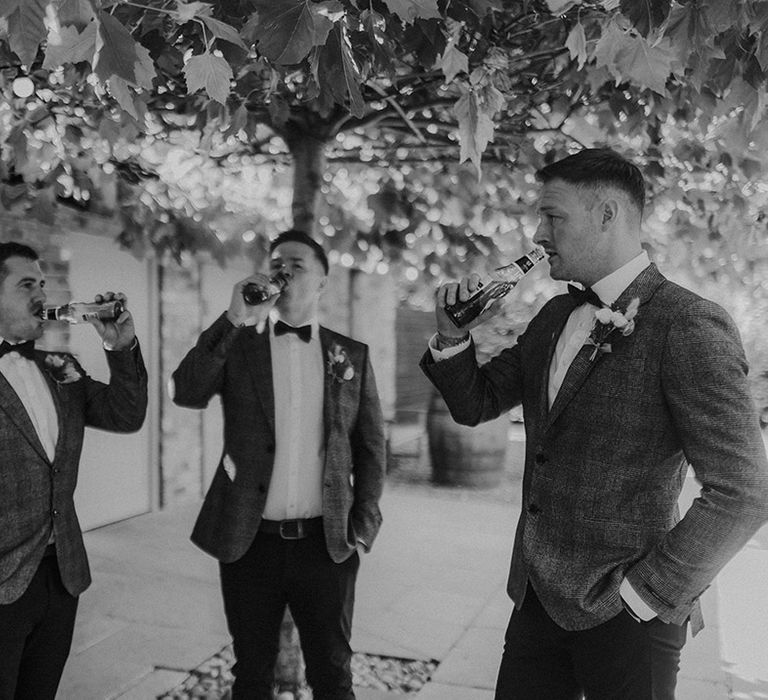 Groomsmen share a beer the morning of the wedding 