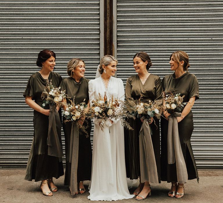 Bridesmaids with green bridesmaid dresses with cowl necks and short bell sleeves 