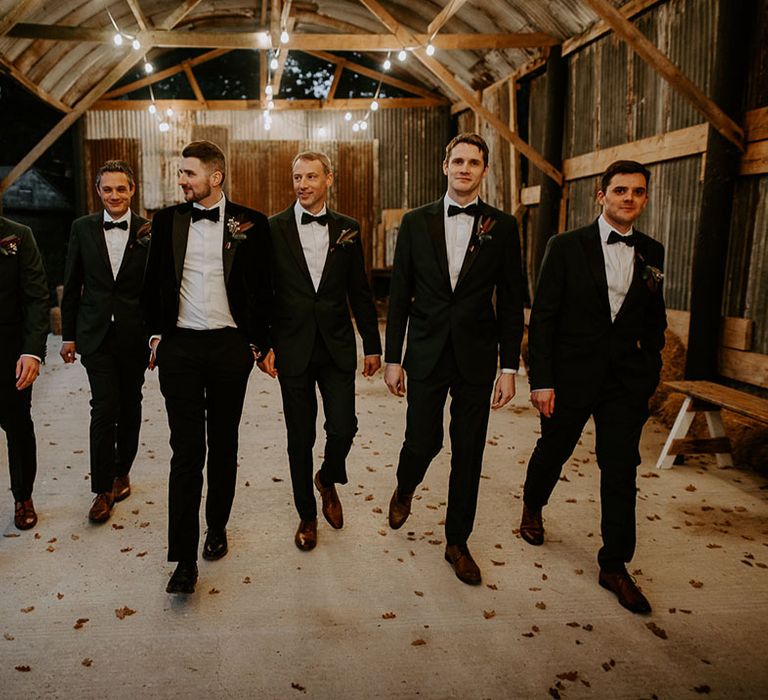 Groom walking with the groomsmen in black tie for rustic wedding at Silchester Farm 