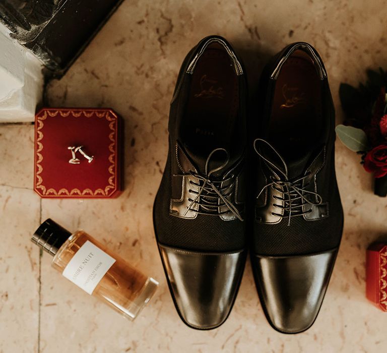 Christian Louboutin black wedding shoes with red velvet wedding ring box, red velvet cufflinks box, and red rose and foliage boutonniere 