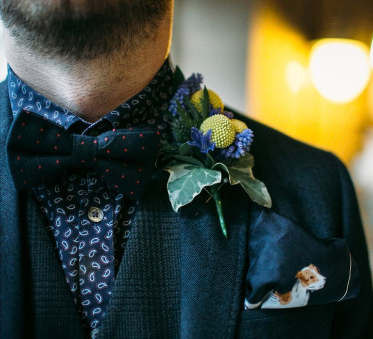 Groom in dark blue suit and shirt with a dark blue pocket square with a drawing of their dog 