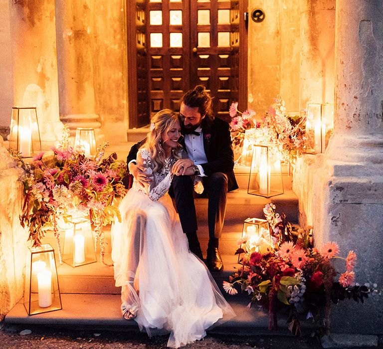 Lanterns with candles in and colourful flowers on the stairs at Elmore Court wedding venue 