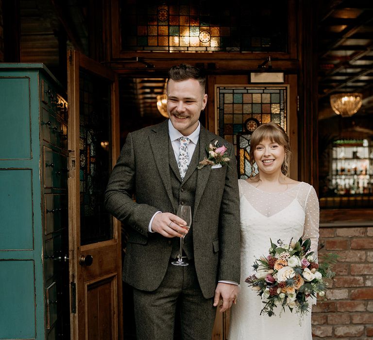 The bride and groom enjoy a celebratory drink on their wedding day 