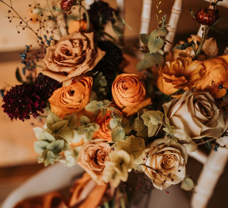 Brown, orange and red wedding bouquet with roses in autumnal shades 