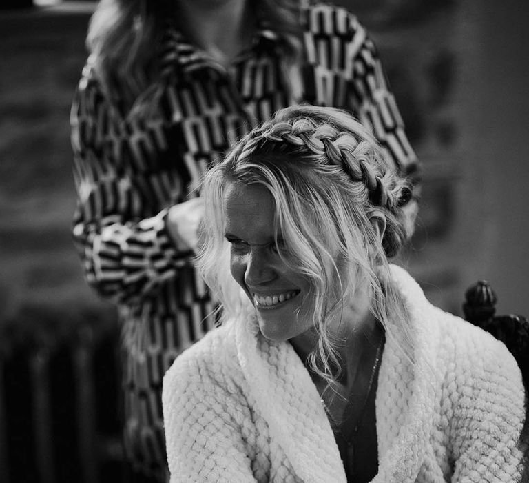 Bride in waffle white robe with braided crown hairstyle 