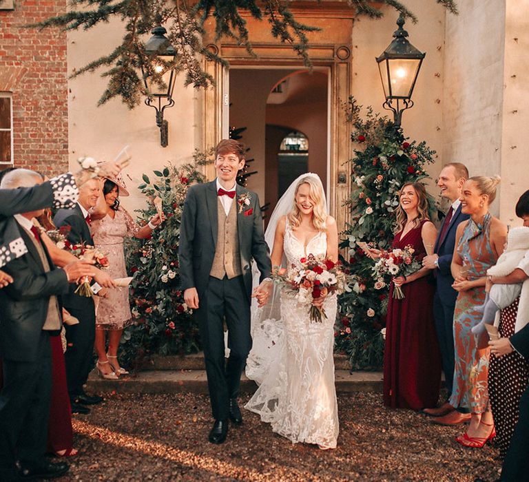 Winter Christmas wedding with the bride and groom walking out to confetti 