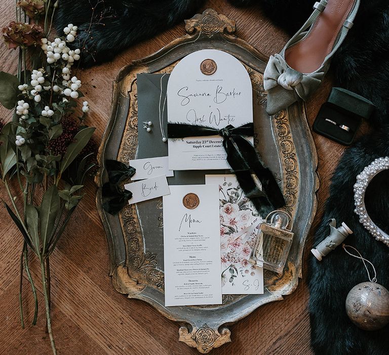 Minimalist wedding stationery and menu with god wax seal surrounded by bridal accessories 