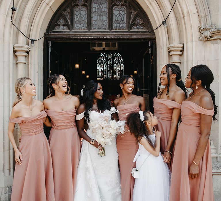 Bridal party photo with the bridesmaids in pink dresses outside church 