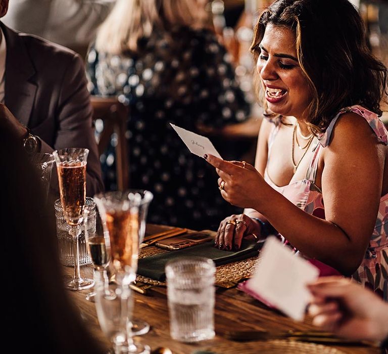 Wedding guests reading their personalised note wedding favours at The Cherry Barn wedding 