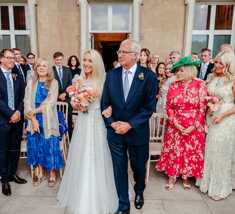 Father of the bride walks the bride down the aisle 