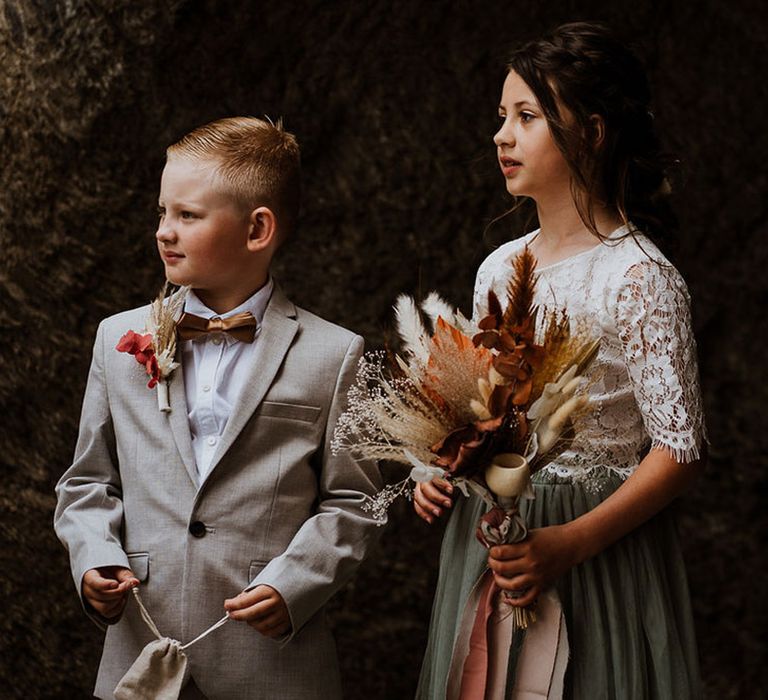 Flower girl in a lace flower girl dress and page boy in a suit at the boho wedding 