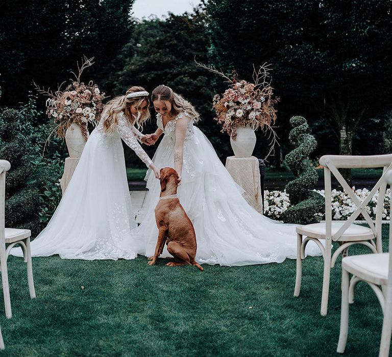 Two brides in princess wedding dresses at elopement with pet dog 