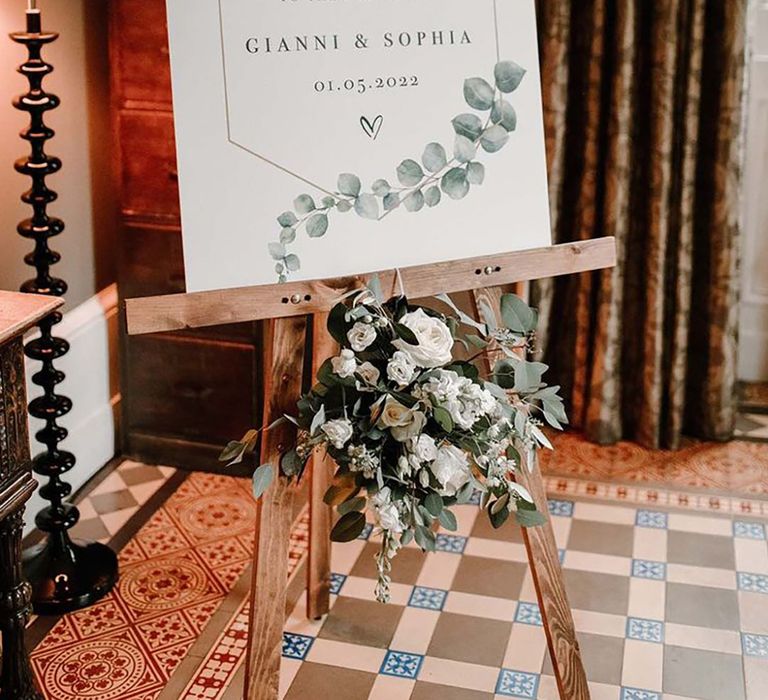 Wedding welcome sign on wooden easel with green leaf design as an idea for green wedding themes 