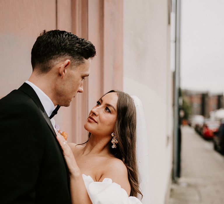 Bride and groom posing for couple portrait as they gaze into each other's eyes 