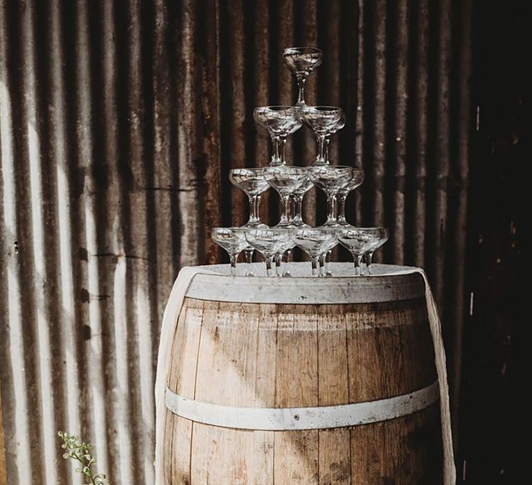 Rustic barrel with champagne tower and minimalist wedding sign 