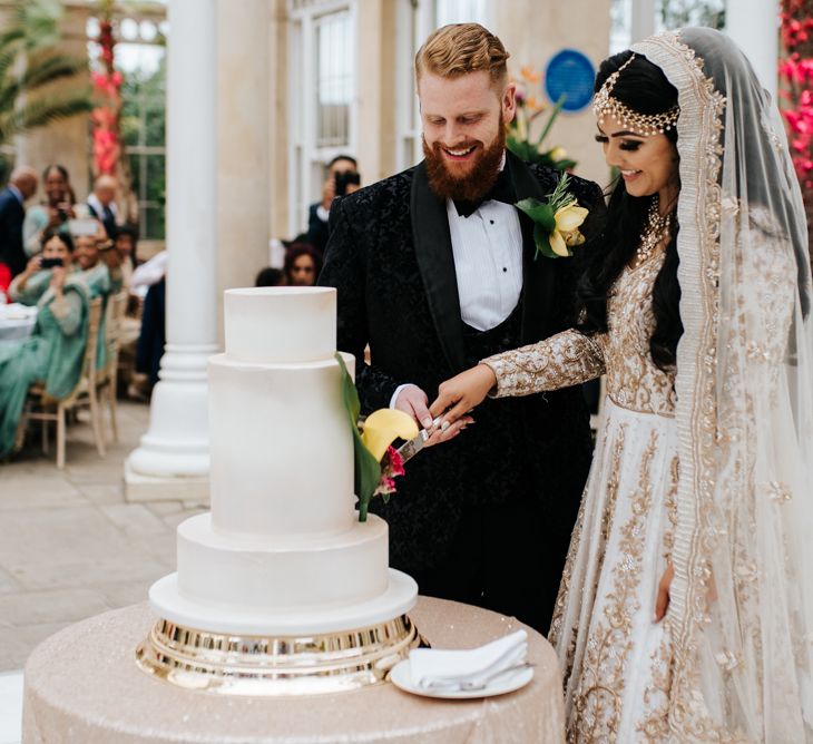 Bride and groom cutting the wedding cake at Syon Park reception