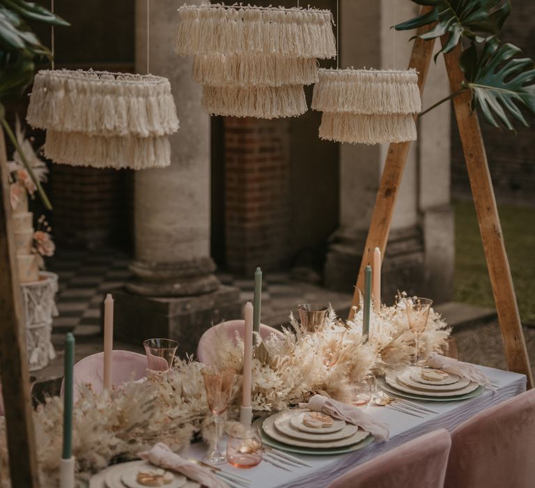 Intimate tablescape with wool chandeliers hanging from a wooden frame 