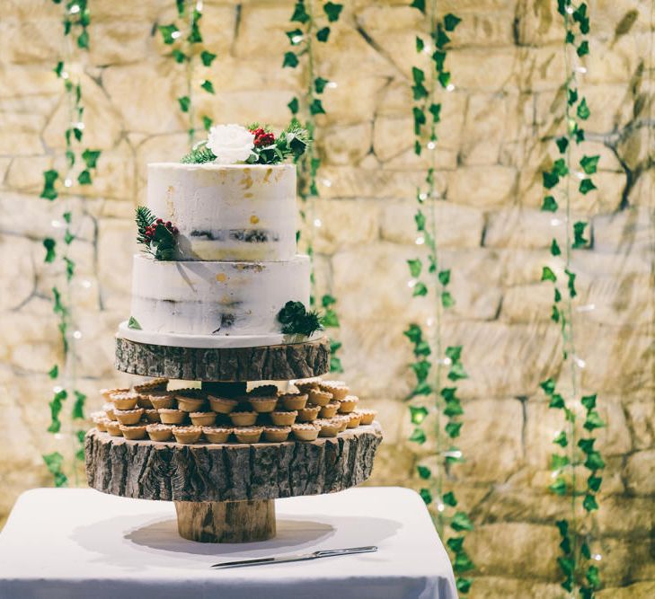 Wedding cake on wooden cake stand with semi-naked cake and mince pies 