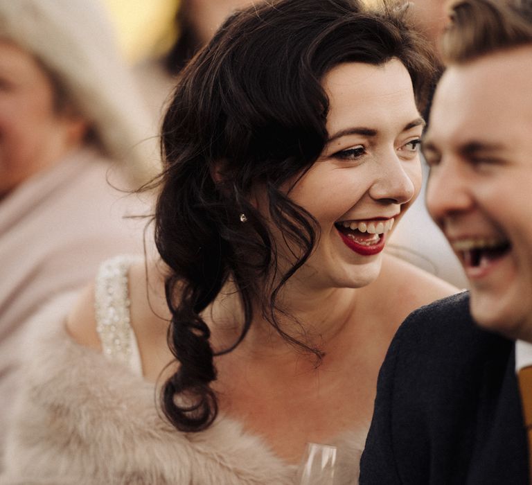 Bride & groom laugh during wedding reception speeches