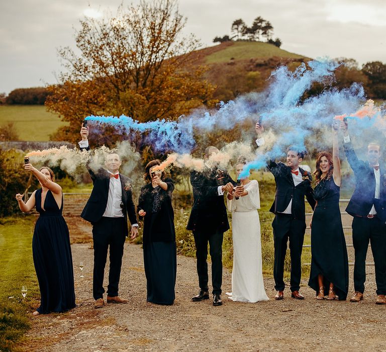 Wedding party with blue smoke bombs outdoors 