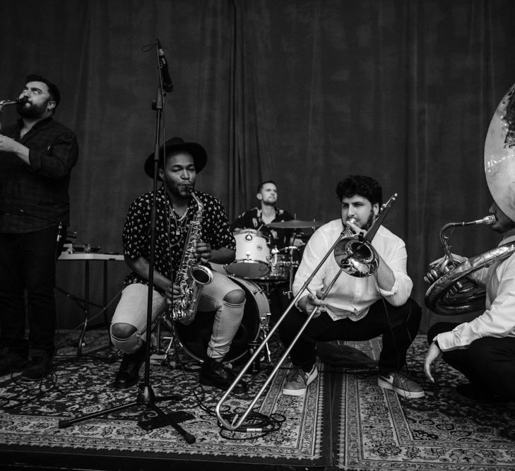 The wedding band - Two saxophonists, a trombone player and a tuba player in front of a drummer. 