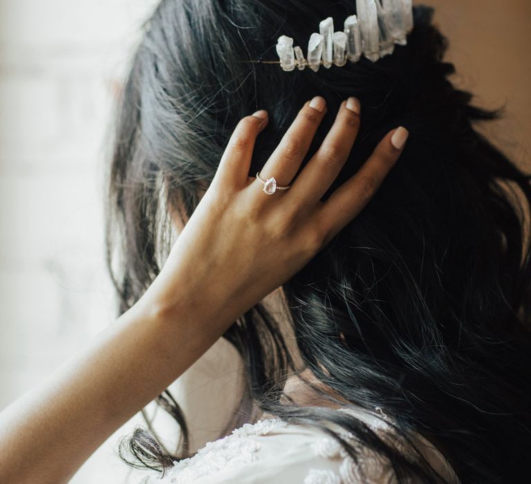 Bride holding her hand to her hair with a pear drop diamond engagement ring 