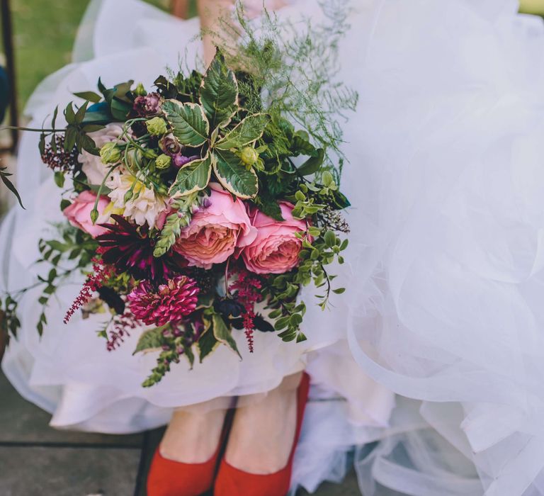 Bright pink rose wedding bouquet with red bridal shoes