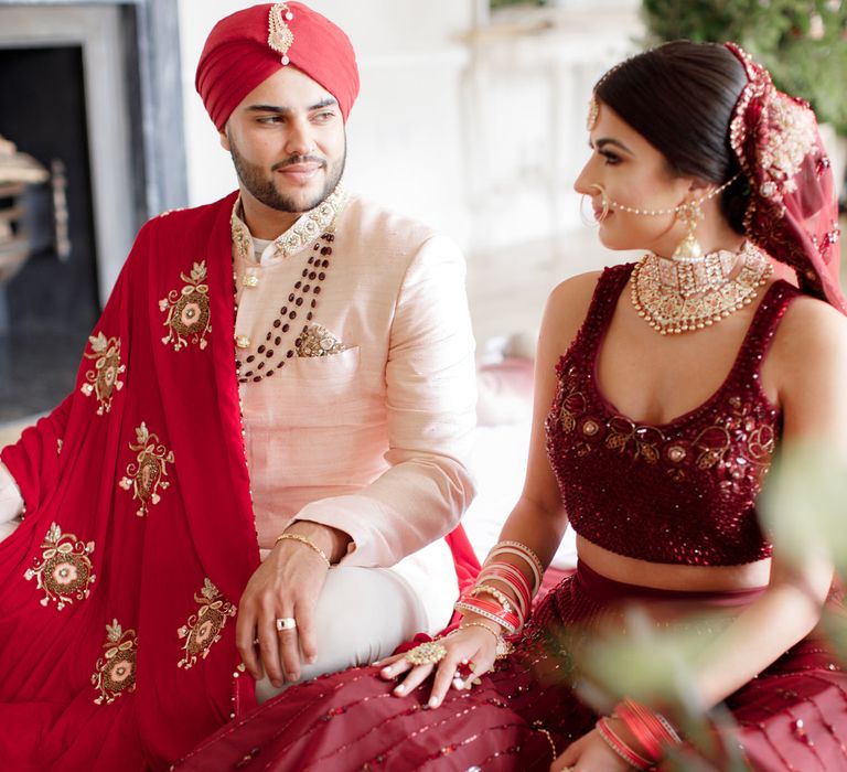 Sikh couple sit together during ceremony 