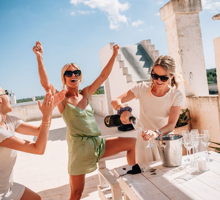 The bride and bridesmaids getting ready and raising a toast