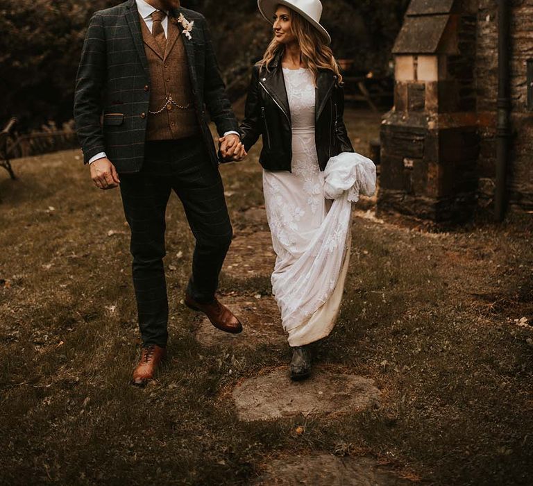 Bride in a leather jacket and bridal hat at intimate seaside elopement 