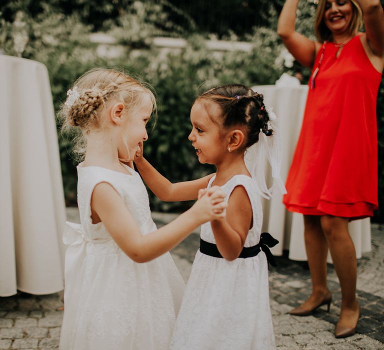 Two young flower girls dancing with each other