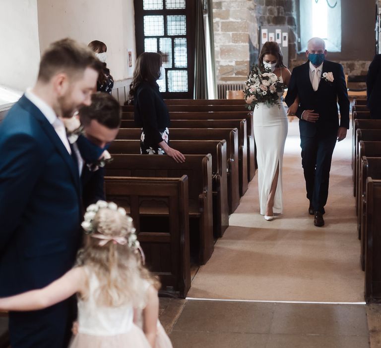 Bride walking down the church aisle in a white slip wedding dress