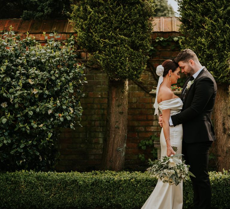 Bridal bun with veil and white wedding bouquet for bride