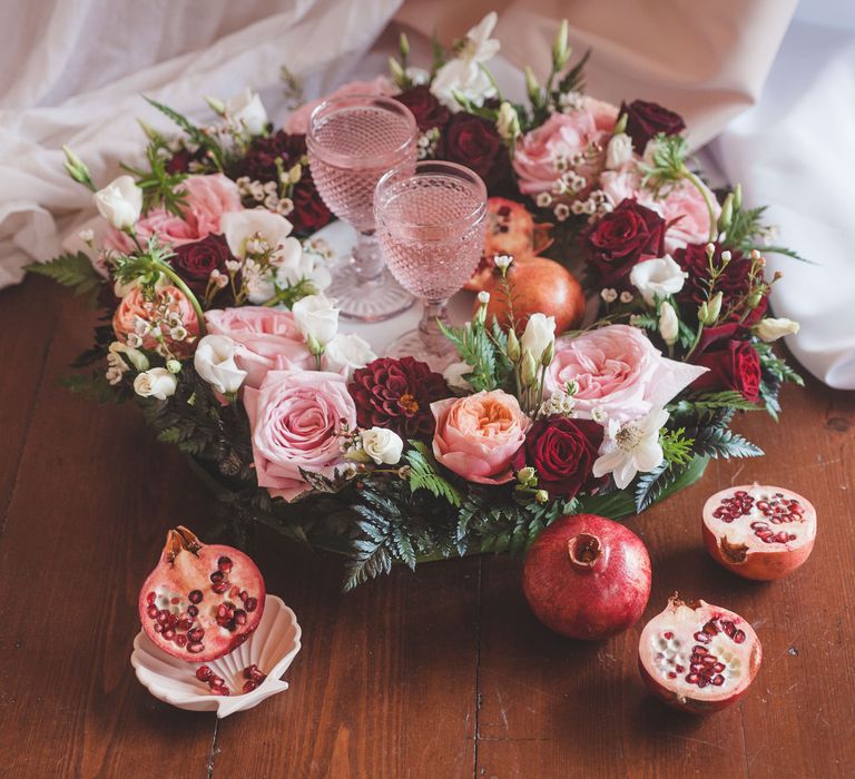 Floral decorated tray with pink, red and white roses and dahlias with green foliage and coloured glass goblets 