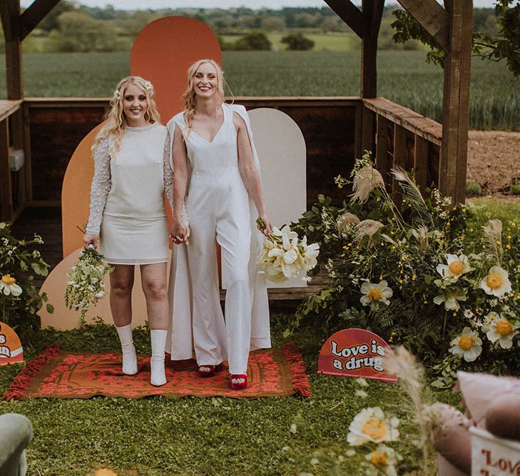 Outdoor LGBTQI+ wedding at Huntsmill Farm with retro signs, wool rugs and wildflower decor 