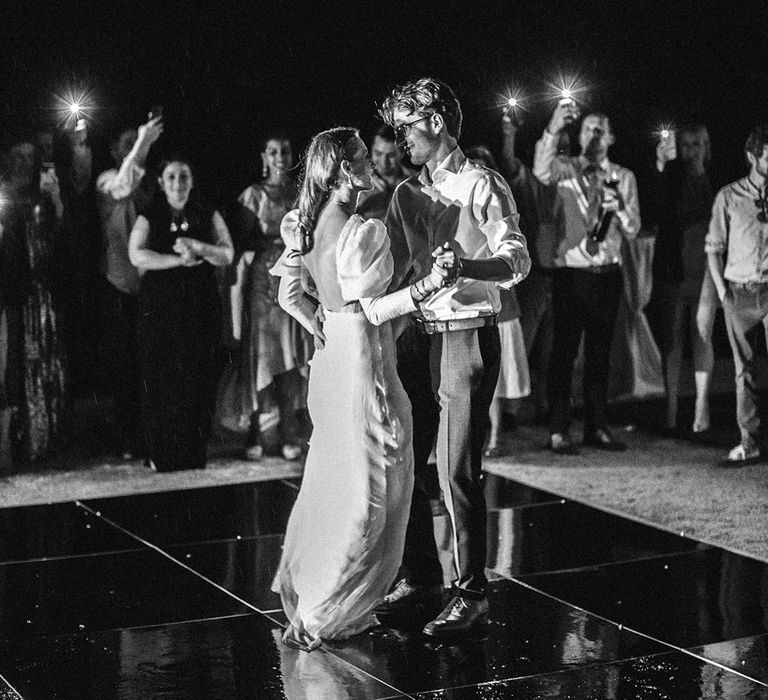 Bride & groom dance outdoors in black & white image