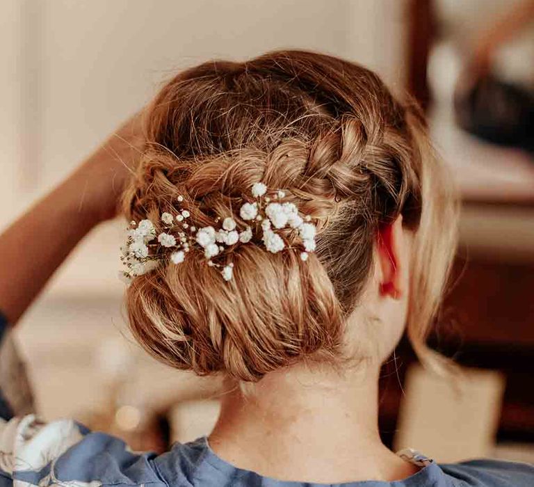 Pinned bridal undo with braid and floral hairpiece