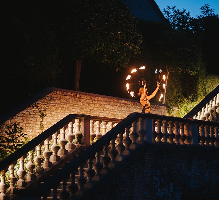 Fire dancer performs outdoors in the dark on wedding day