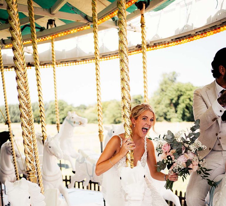 Bride clutching blush bouquet on carousel at Preston Court