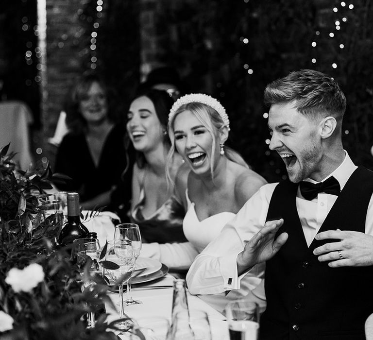 Bride and groom laughing during the wedding speeches at Northbrook Park 