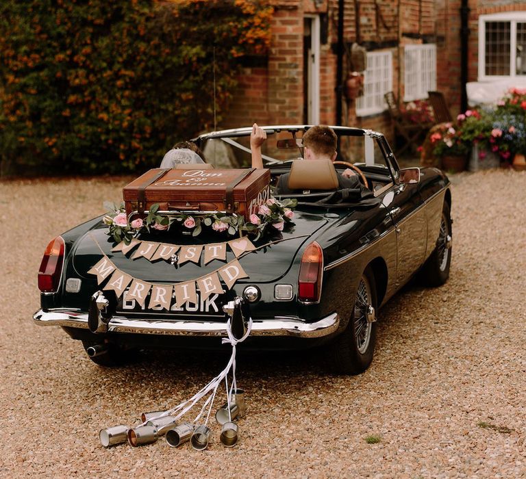 Vintage wedding car with bunting and can decor