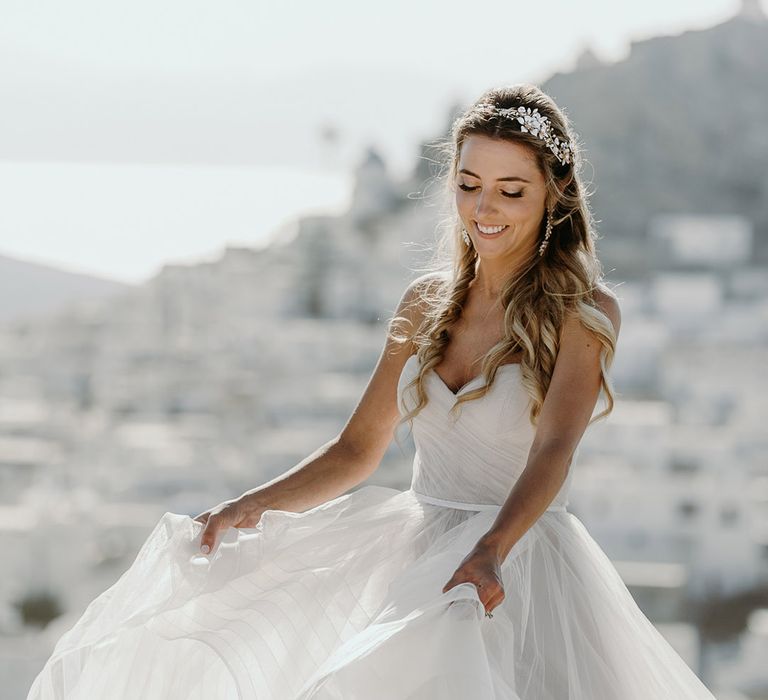 Bride holds her full Watters wedding gown with sweetheart neckline