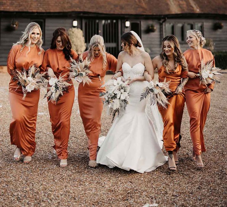 bridesmaids wearing burnt orange satin bridesmaid dresses